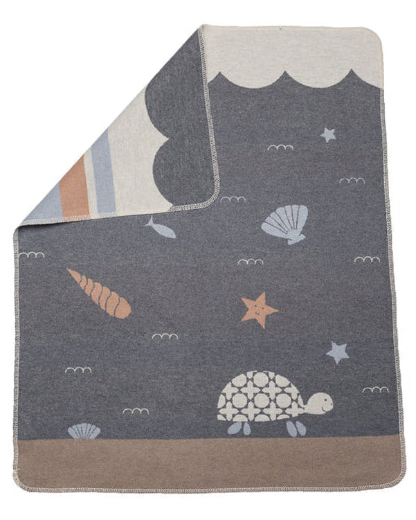 Children's blanket with ocean-themed design featuring a turtle, starfish, and shells on a gray background.