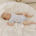 Baby lying on a white blanket in a cozy setting
