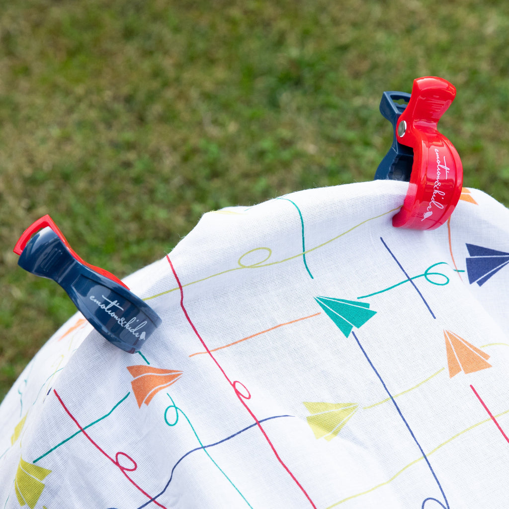 Colorful paper plane muslin with a pattern of lines and shapes on a grassy background